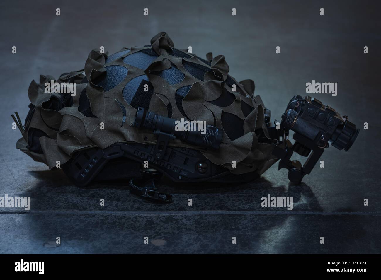 Moderne Spezialkräfte kämpfen Helm mit Nachtsichtgerät, Taschenlampe und Tarnnetz auf dunklem Hintergrund. Stockfoto