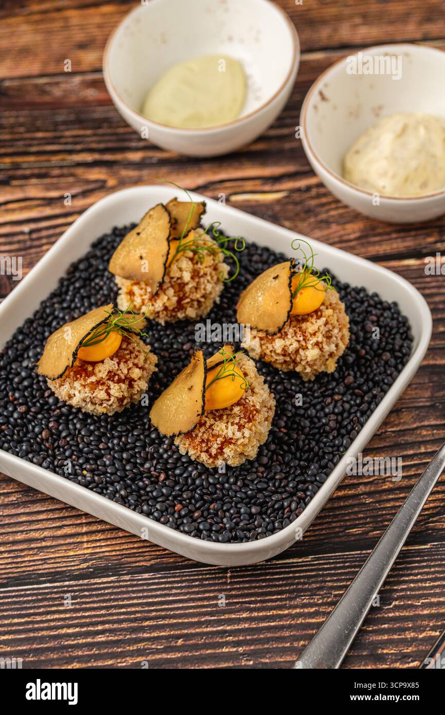 Gourmet-Quinoa-Kugeln mit knuspriger Textur und kunstvoller Dekoration Stockfoto