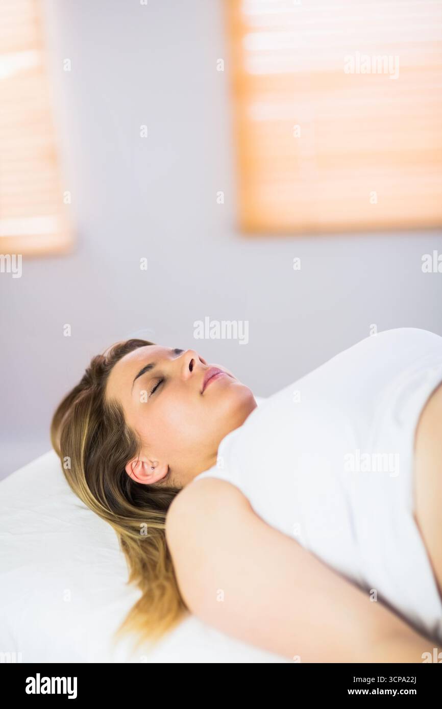 Bestrahlungstisch mit weißem Blatt unter weichem Licht, das durch Holzjalousien an der Wand filtert Stockfoto