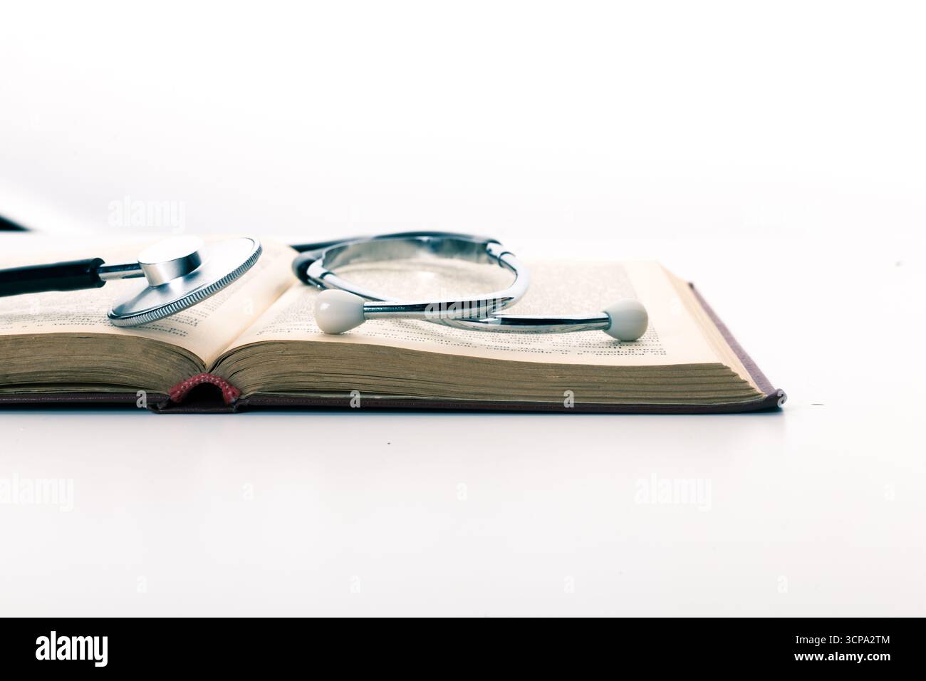 Medizinisches Lehrbuch mit Stethoskop auf den Seiten in hellem Setting Stockfoto