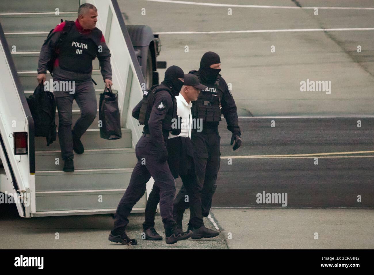 Vladimir Plahotniuc, Moldovan oligarch facing charges over a $1 billion bank fraud, is escorted by police out of an airplane after being extradited from Greece, where he was detained in July, at the Eugen Doga International Airport in Chisinau, Moldova, Thursday, Sept. 25, 2025, ahead of parliamentary elections taking place on Sept. 28. (AP Photo/Vadim Ghirda) Stockfoto