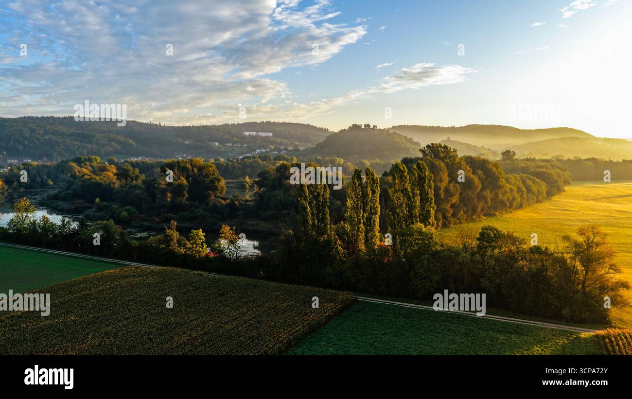 Morgenlicht über üppigen Wäldern, Feldern und Hillside Village Stockfoto