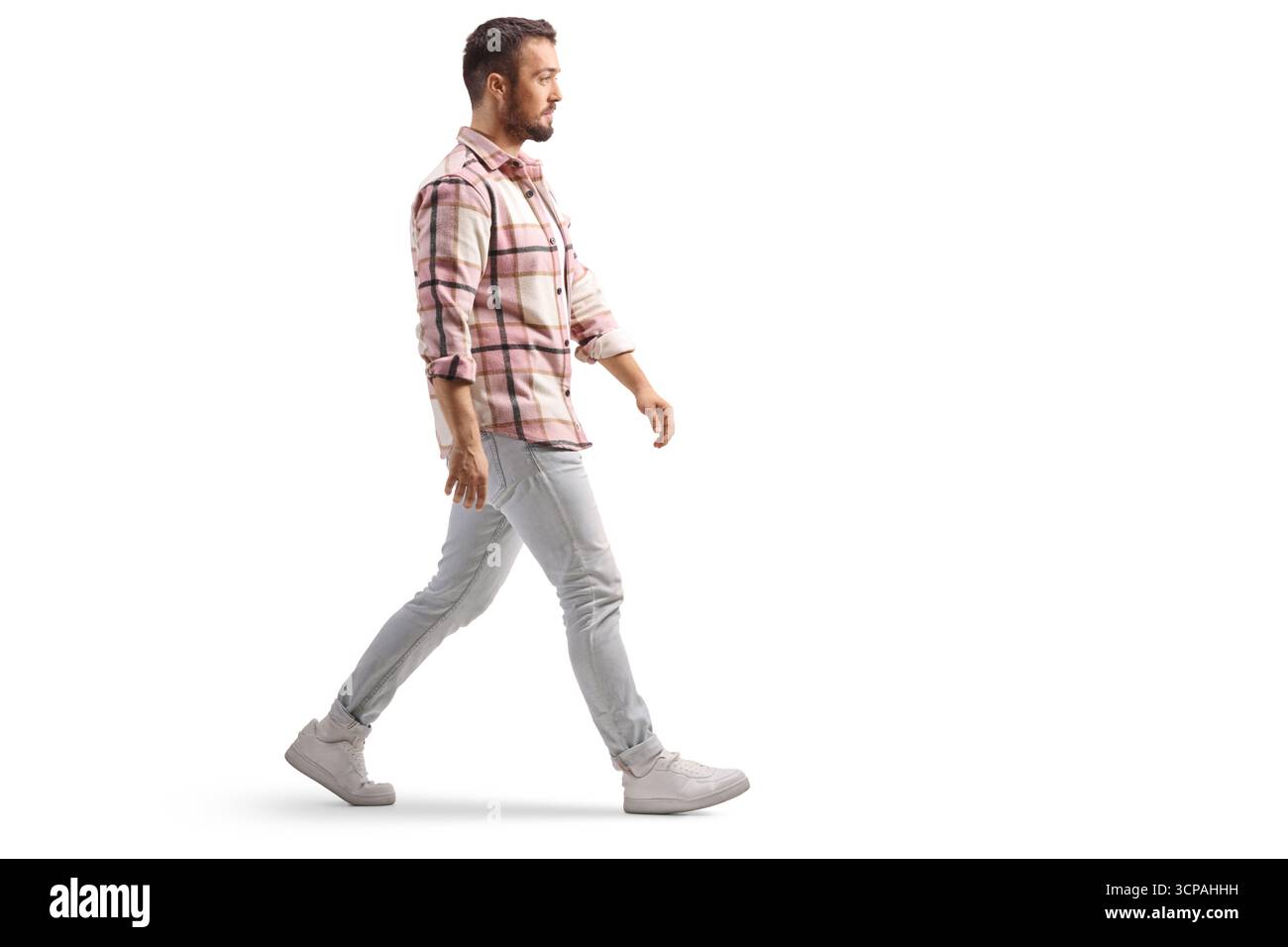 Profilaufnahme eines Mannes in Jeans und kariertem Hemd, der isoliert auf weißem Hintergrund läuft Stockfoto