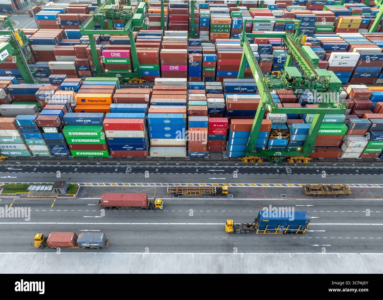 Singapur, Singapur - 06. Dezember 2024: Aus der Vogelperspektive der Container des Pasir Panjang Terminals, eine Symphonie aus Rot, Blau und Grün, die hoch gestapelt ist und auf ihre Reise über die Meere wartet. Stockfoto