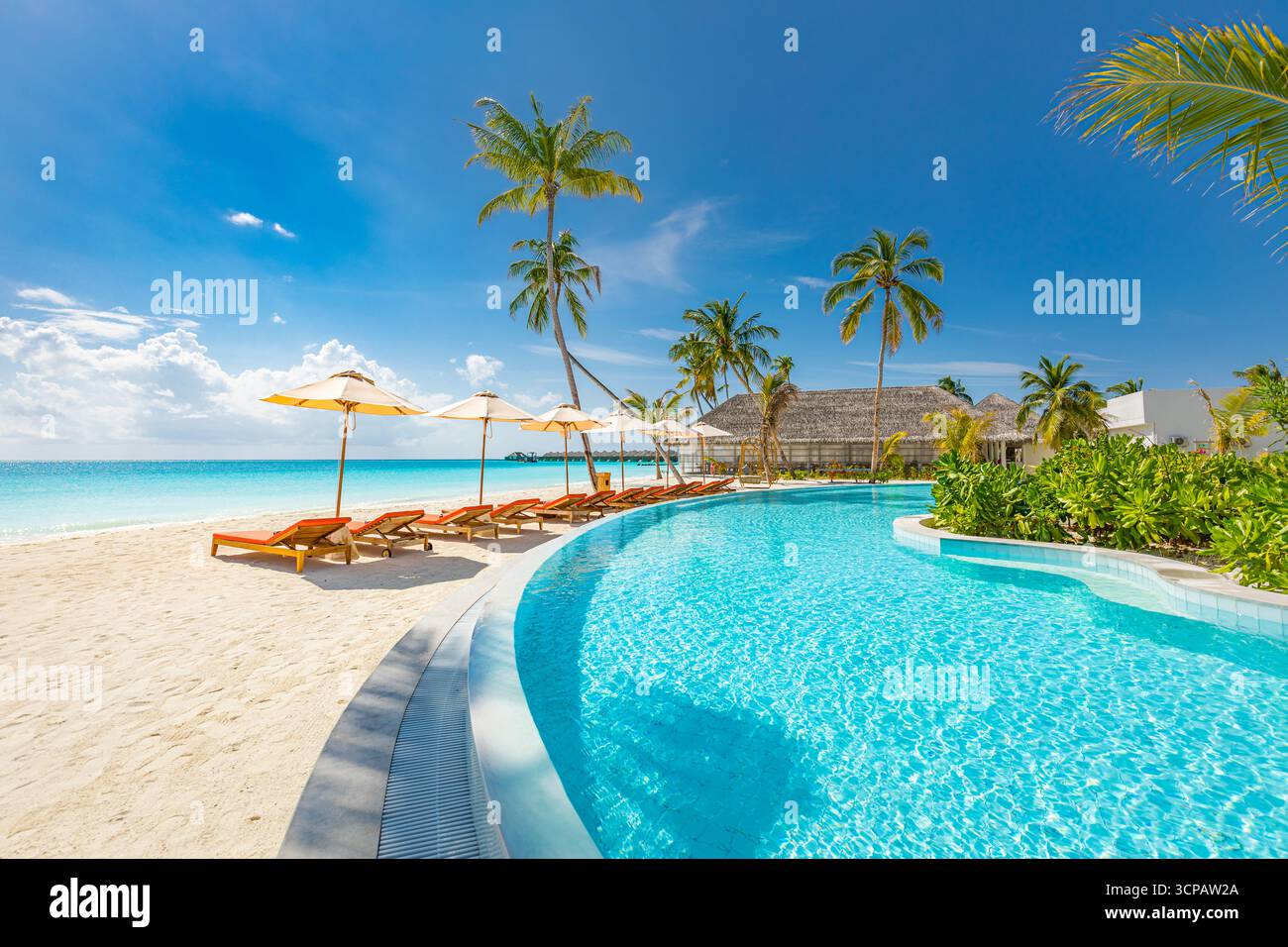 Atemberaubende Landschaft, Swimmingpool, blaue Wolken. Tropisches Resort-Hotel auf den Malediven. Fantastische Entspannung und friedliche Atmosphäre, Stühle, Sonnenliegen Stockfoto