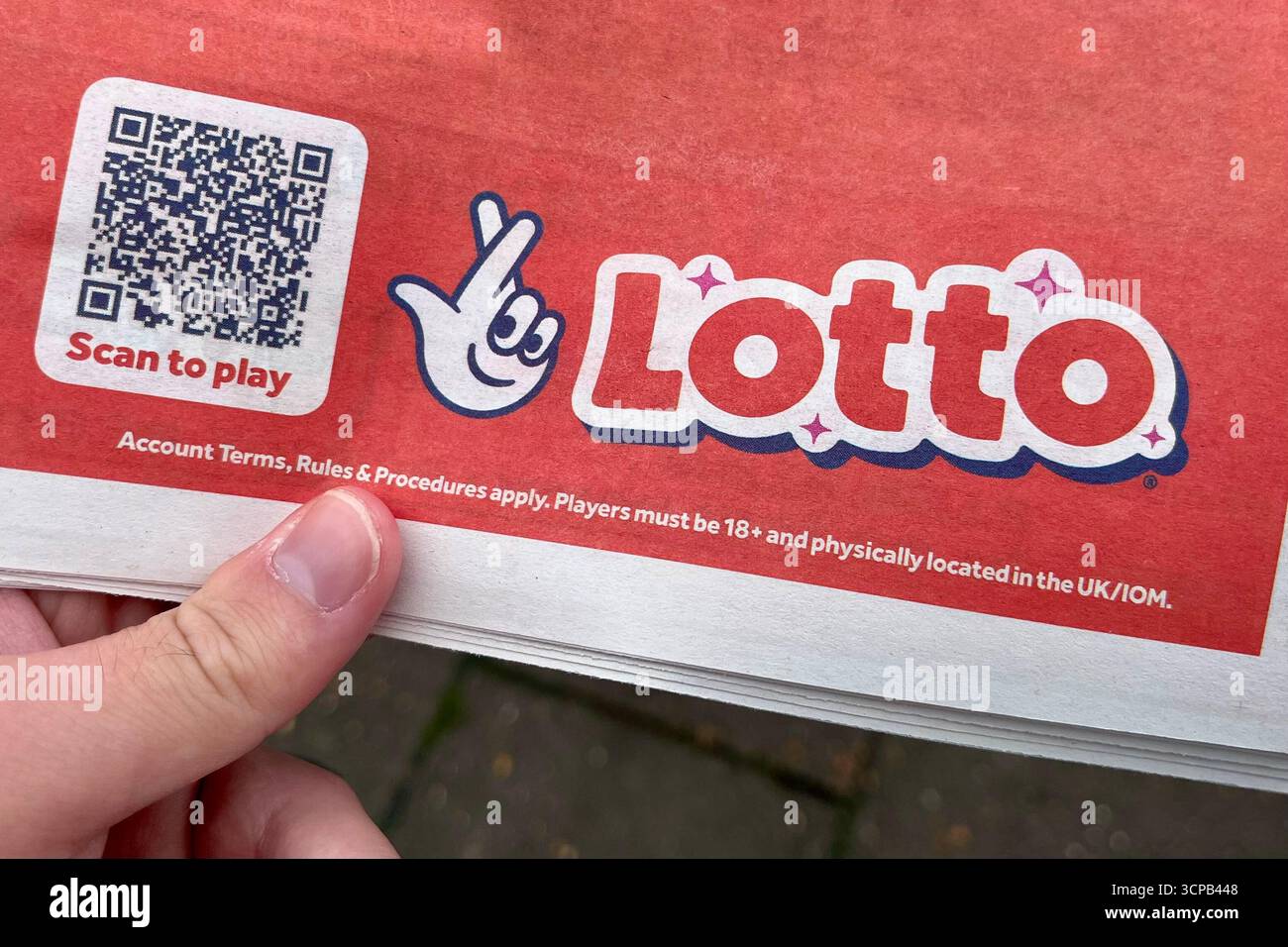 Lotto Scan to Play Werbung mit dem neuen National Lottery Logo auf einer Zeitung. September 2025. - Smartphone-aufgenommenes Stockfoto
