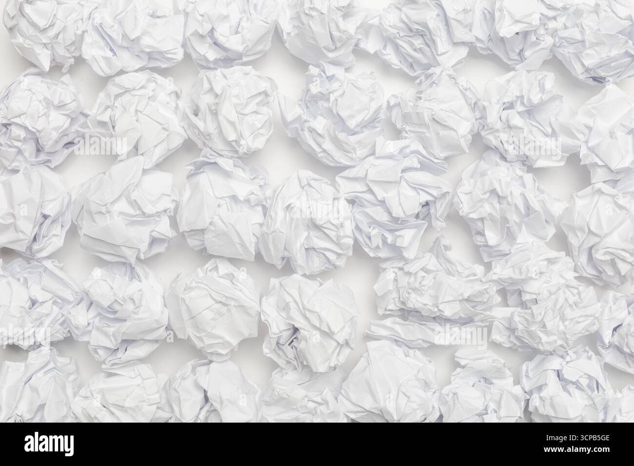 Zerknittertes weißes Papier, das ein abstraktes Muster auf einer Ebenen Oberfläche erzeugt Stockfoto