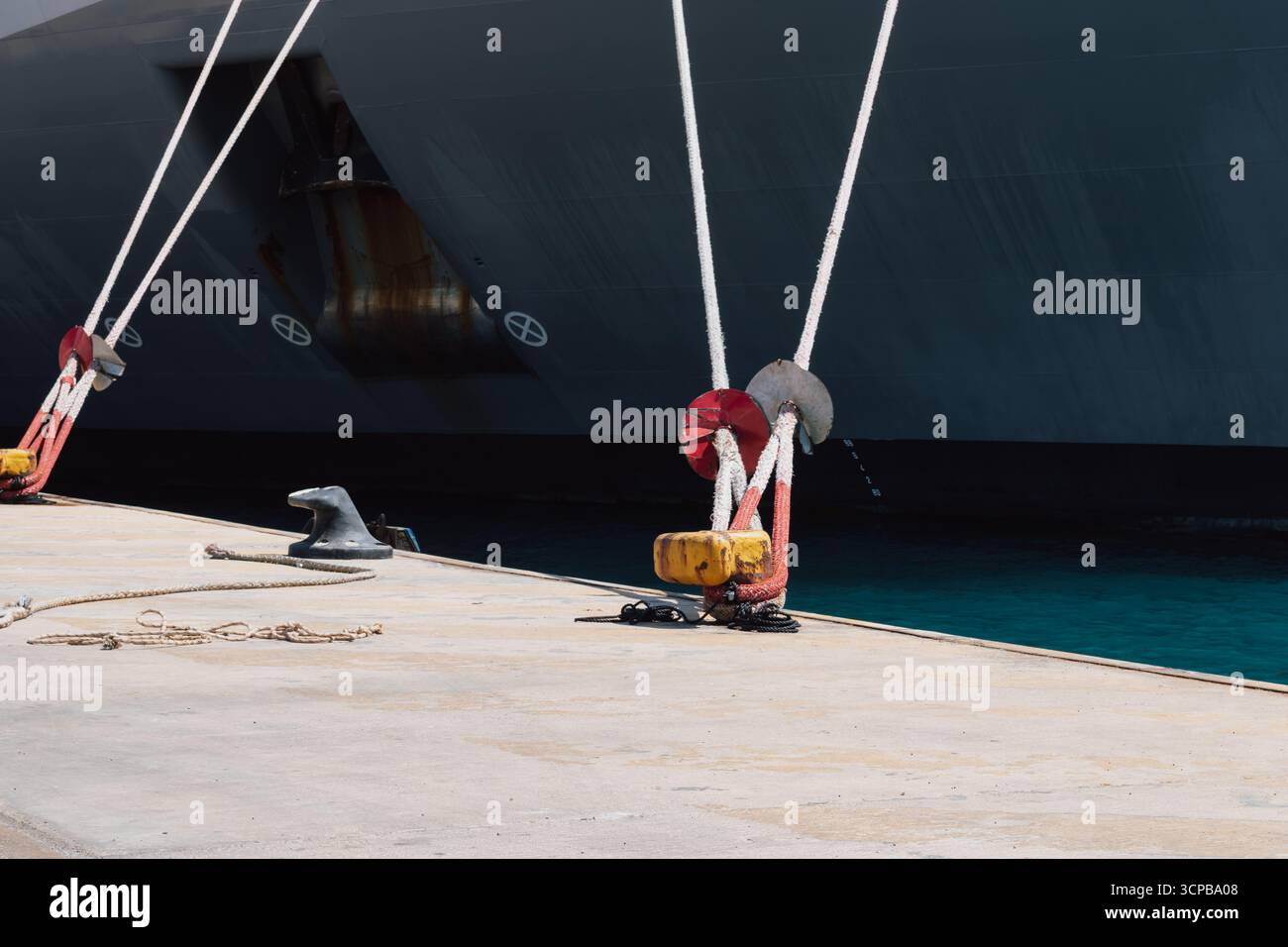 Festmachen eines Schiffes im Hafen mit Festmacherleinen an einem Schiffspoller am Kai Stockfoto