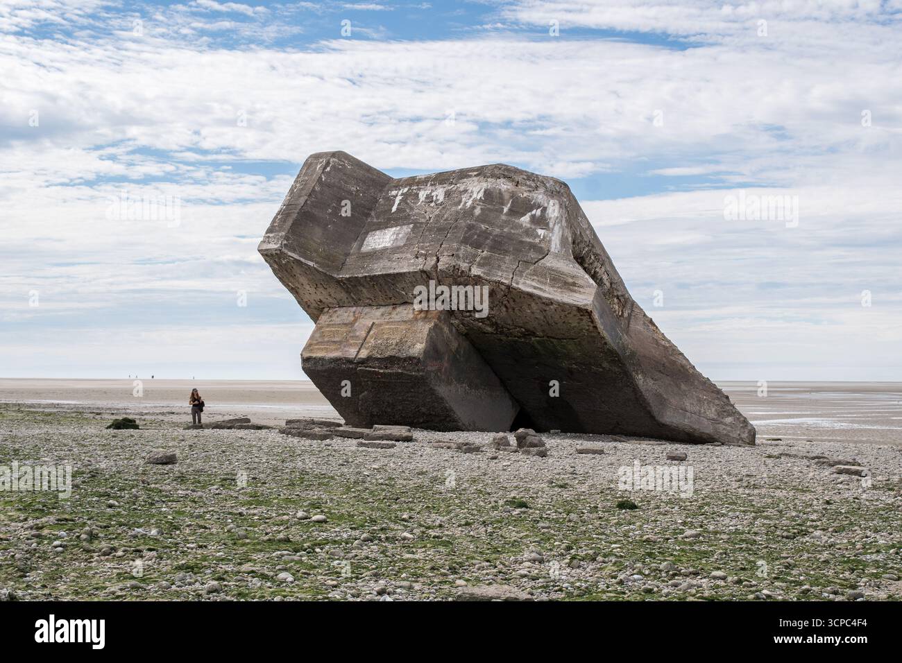 Massiver deutscher Betonbunker aus dem Zweiten Weltkrieg steht geneigt am Kiesstrand von Pointe d’Hourdel, dessen verwitterte Oberfläche jahrzehntelang zeugt Stockfoto
