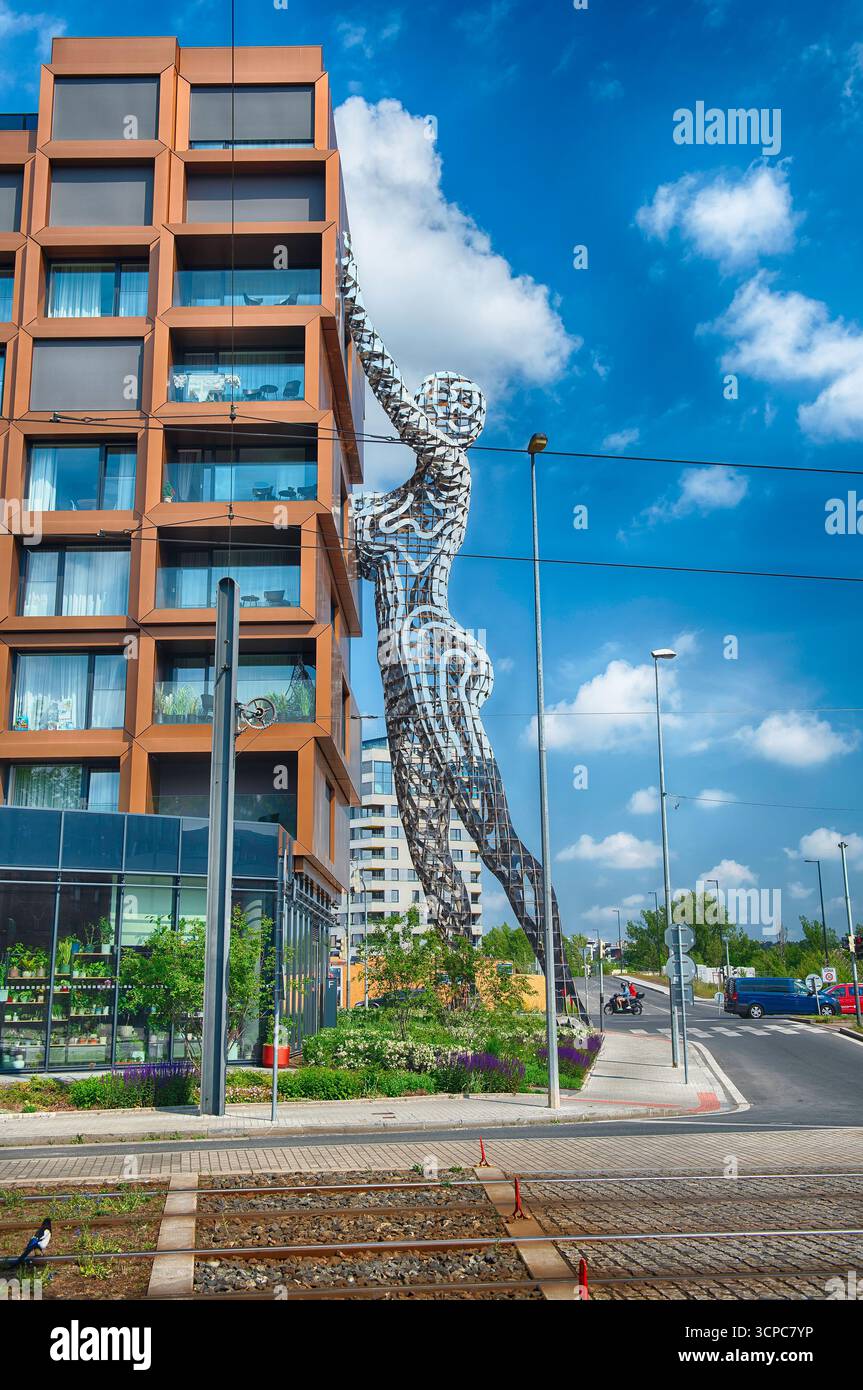 PRAG - 12. MAI 2024: Riesige Metallstatue, die nach einem zeitgenössischen Gebäude greift, von David Cherny in Prag, Tschechien, an einem sonnigen Sommertag Stockfoto PRAG - 12. MAI 2024: Riesige Metallstatue, die nach einem zeitgenössischen Gebäude greift, von David Cherny in Prag, Tschechien, an einem sonnigen Sommertag Stockfoto