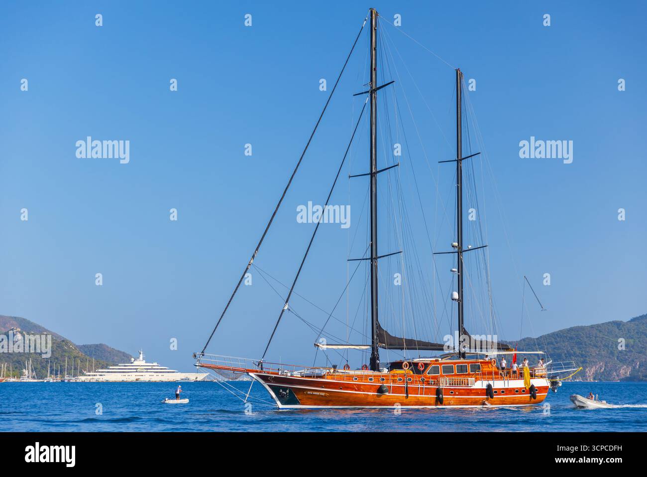Marmaris, Türkei - 21. August 2024: Eine klassische Segelyacht aus Holz mit zwei hohen Masten fährt auf dem ruhigen blauen Meer. Reichhaltige Holzterrasse und Takelage Contras Stockfoto
