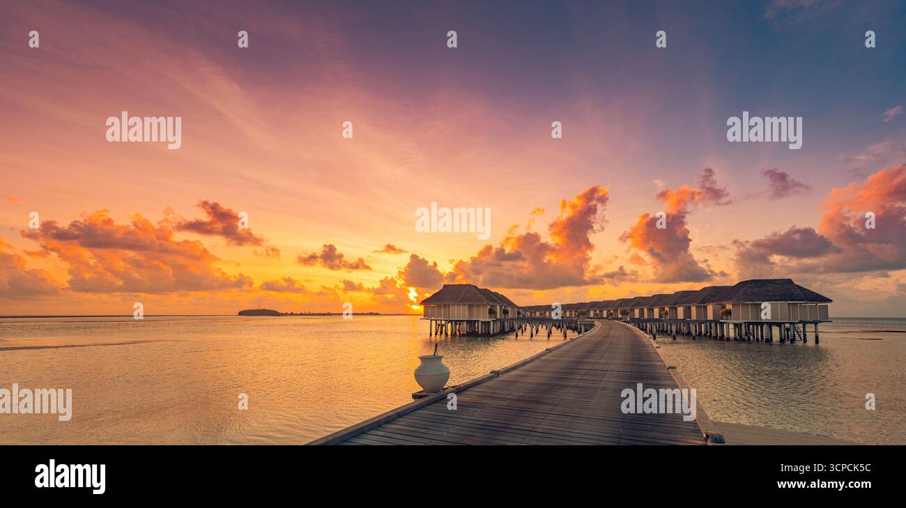 Herrliche Panorama fantastischer Sonnenuntergang Malediven Wasservillen. Private Bungalows im Luxusresort, ruhiges Meer, farbenfroher Himmel. Bester Sommerurlaub Stockfoto