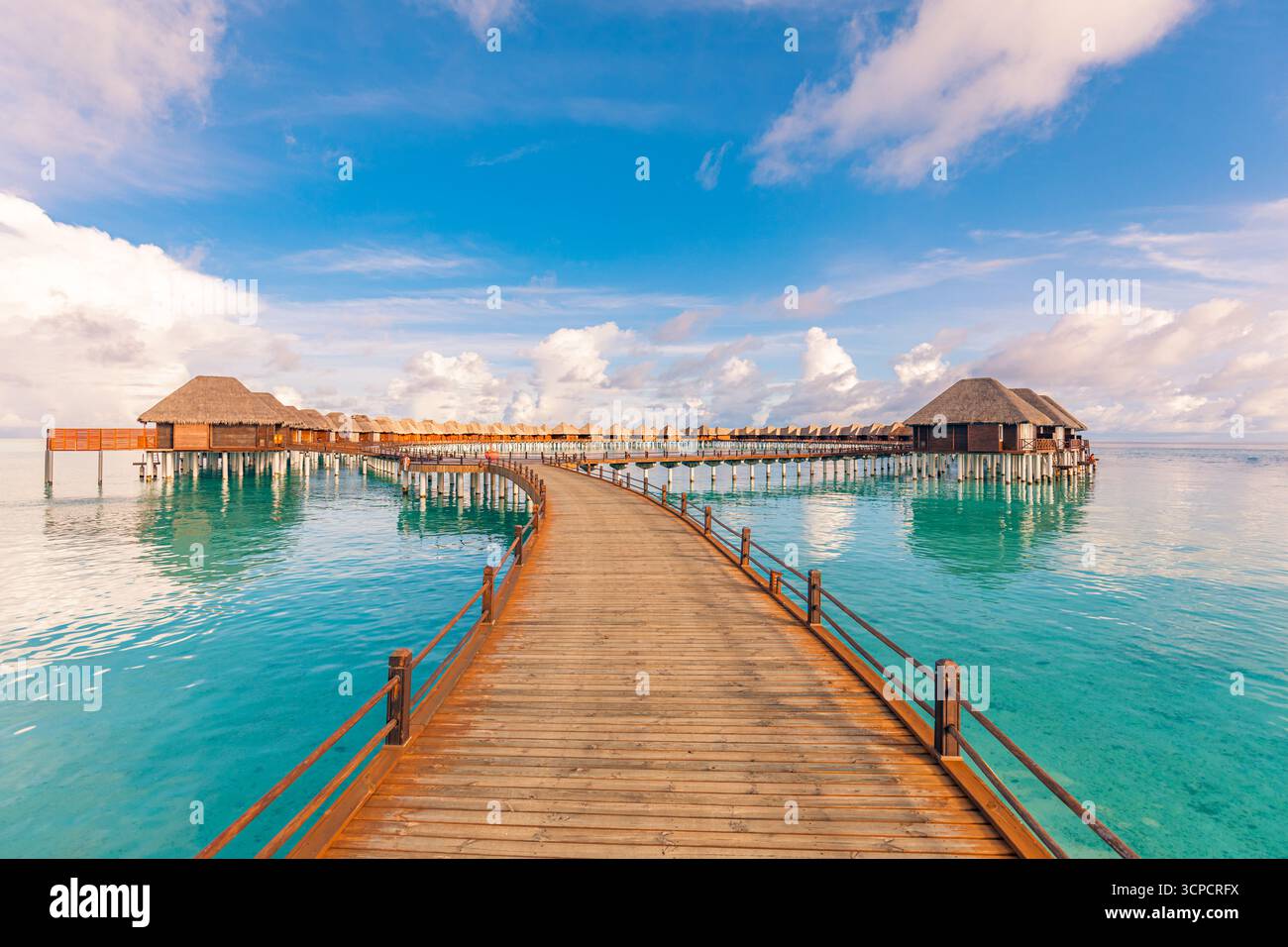 Atemberaubende Wasservillen in den Malediven Inseln Resorts mit ruhigem Pier ruhigem Meer Horizont unter sonnigem blauem Himmel. Beliebte tropische Sommerferienlandschaft Stockfoto