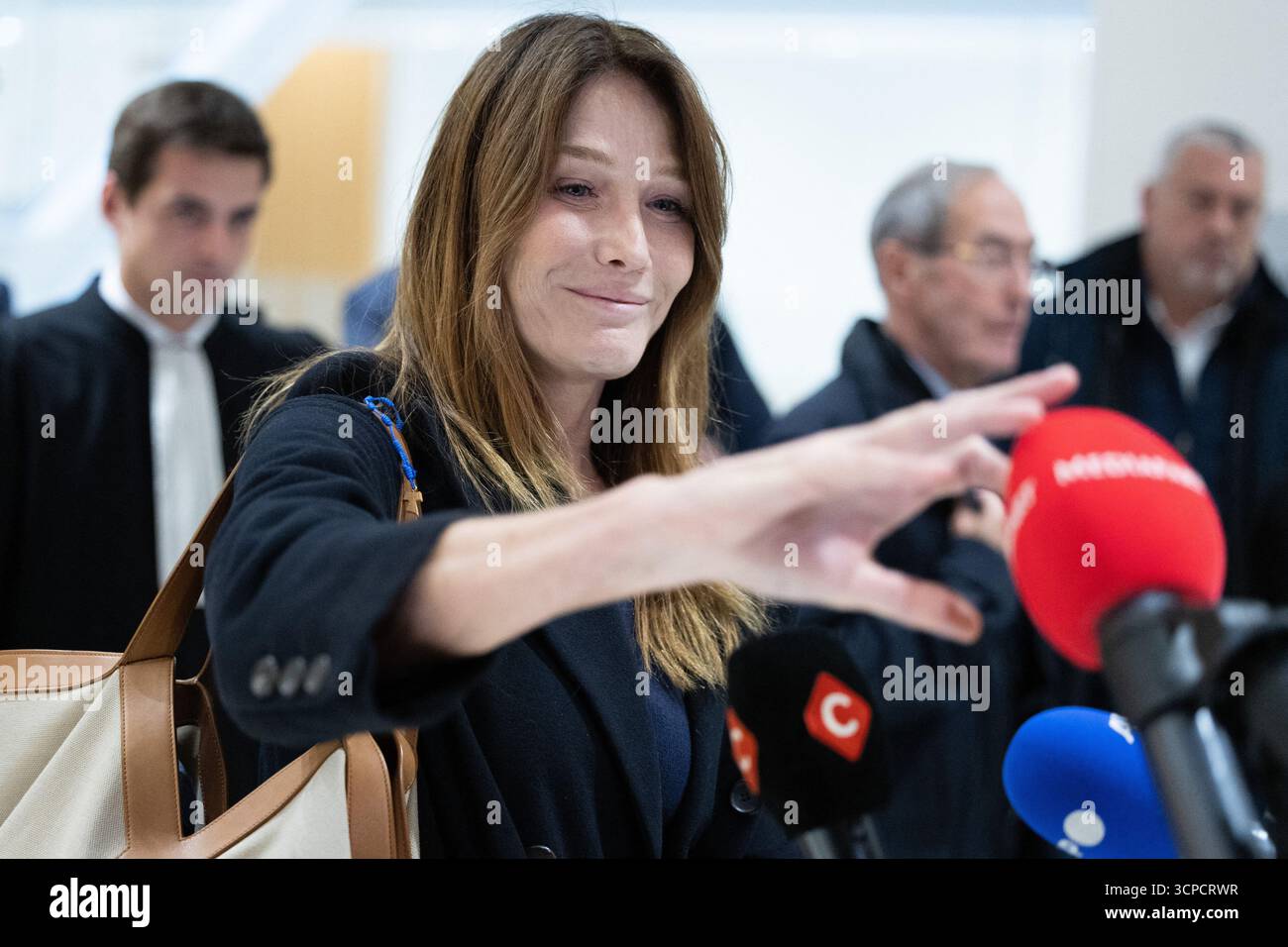 Paris, Frankreich. September 2025. Carla Bruni schnappt sich die Windschutzscheibe eines Mediapart-Mikrofons, nachdem ihr Mann und ehemaliger französischer Präsident Nicolas Sarkozy am 25. September 2025 vor dem Gericht in Paris, Frankreich, über sein Gerichtsverfahren wegen illegaler Wahlkampffinanzierung aus Libyen für seinen erfolgreichen Präsidentschaftsantrag 2007 gesprochen hatte. Sarkozy wurde zu fünf Jahren Gefängnis verurteilt. Foto: Raphael Lafargue/ABACAPRESS.COM Credit: Abaca Press/Alamy Live News Stockfoto