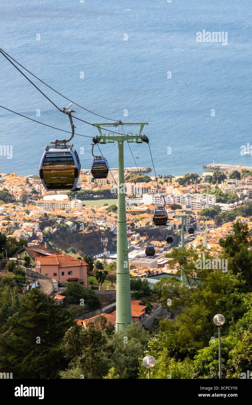 Die Teleférico do Funchal, oder Madeira-Seilbahn, befördert Passagiere in blauen Gondeln hoch über der Stadt Funchal, Portugal, mit Panoramablick Stockfoto