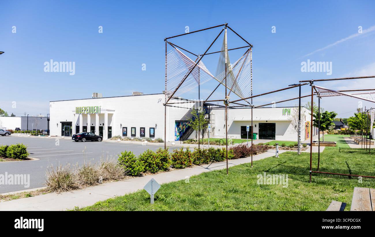 Charlotte, North Carolina, USA-13. April 2025: The Independent Picture House, Raleigh St. Diagonale Ansicht der Vorderseite mit Cal Graffiti-Garten. Stockfoto