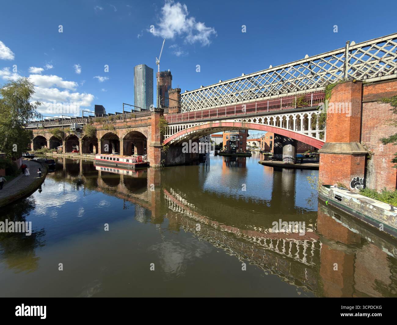 Wetter in Großbritannien: Sonnig in Manchester. Reflexion der Eisenbahnbrücke im Bridgewater-Kanal bei Castlefield Stockfoto