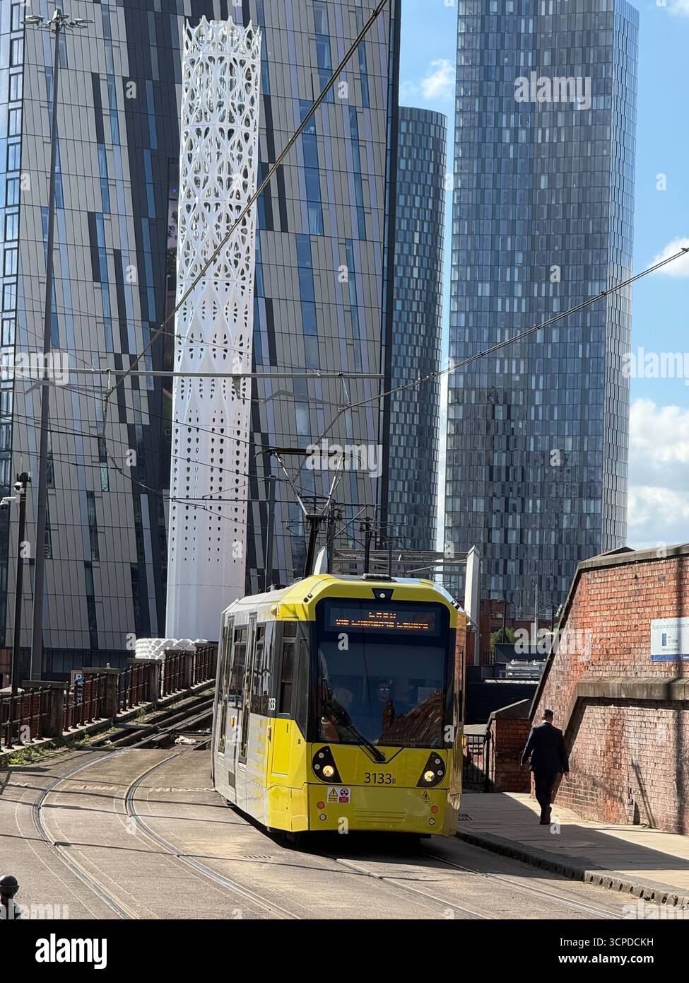 Wetter in Großbritannien: Sonnig in Manchester. Straßenbahn mit neuen Wolkenkratzern des Deansgate Square Complex dahinter Stockfoto