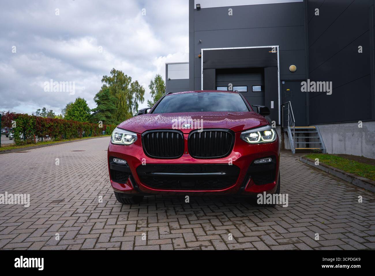 Nahaufnahme der Vorderansicht des roten BMW X4 auf einer asphaltierten Einfahrt Stockfoto