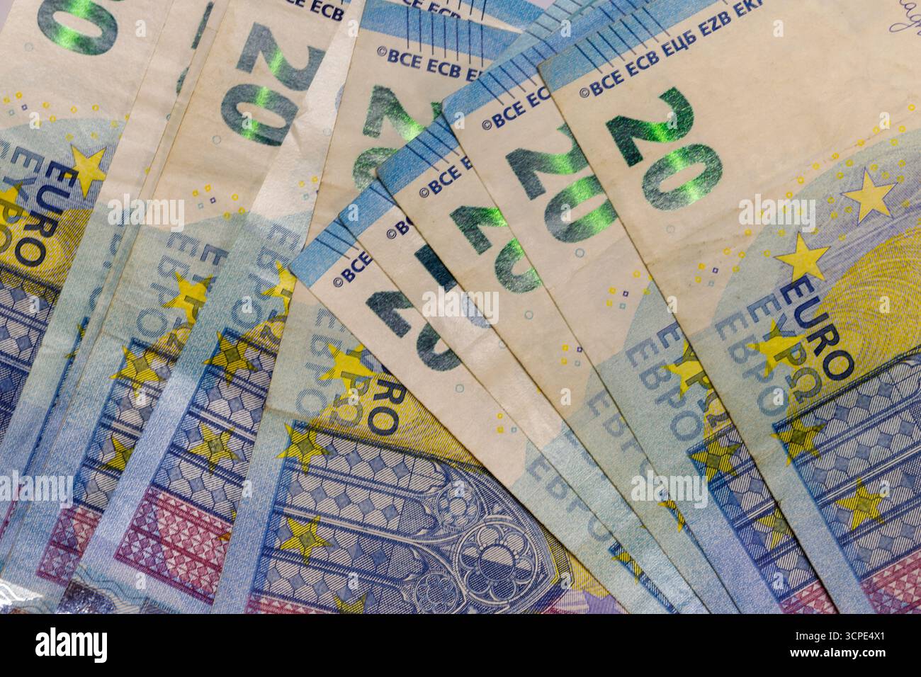Nahaufnahme von mehreren 20-Euro-Banknoten, aufgefächert, um ihre Merkmale zu zeigen. Vorherrschende Farben sind hellbeige, blau, gelb und leicht rosa Details. Stockfoto