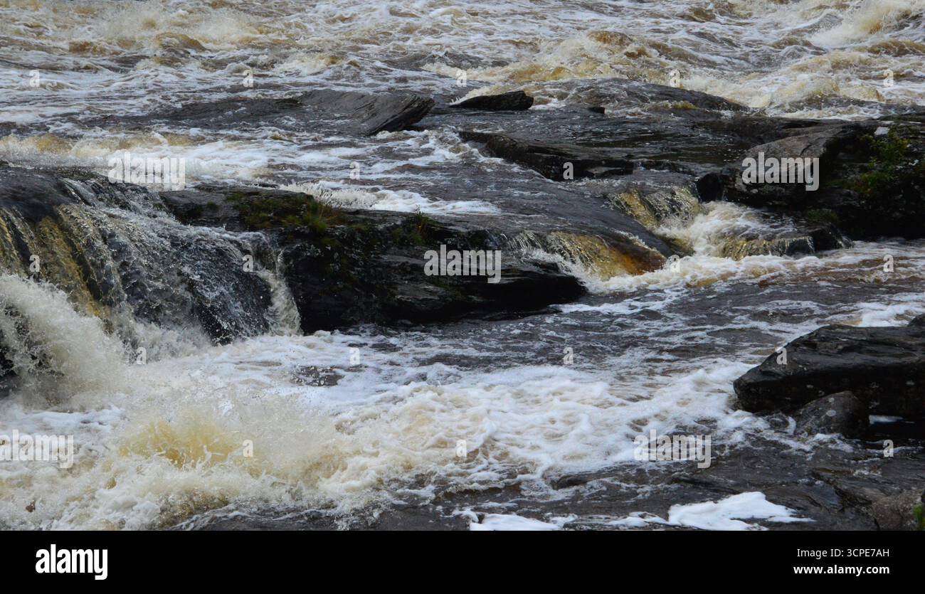 Rauschendes Wasser an den Falls of Dochart, Killin, Schottland. Nahaufnahme der turbulenten Stromschnellen im August, die die Kraft und Bewegung zeigen. Stockfoto