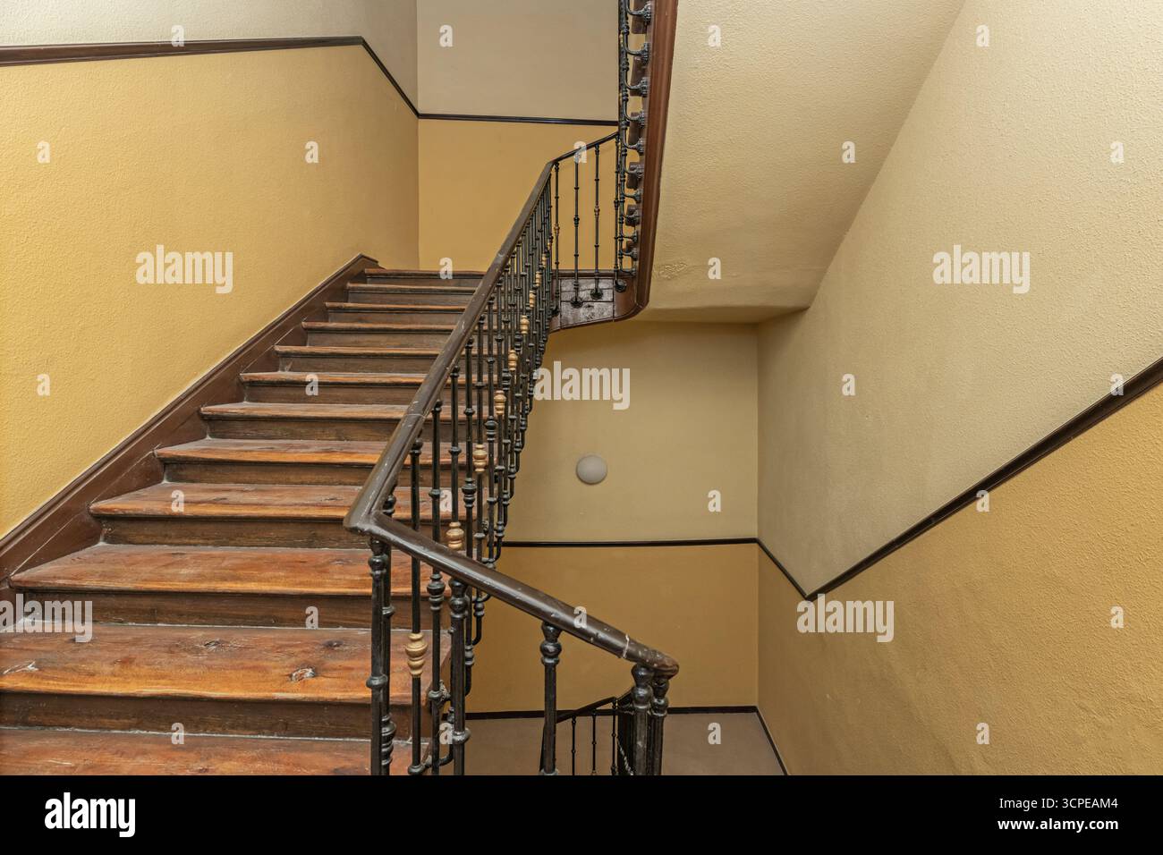 Treppe mit antikem Messing-Handlauf und indirekter Trittstufenbeleuchtung für einen dramatischen Effekt Stockfoto
