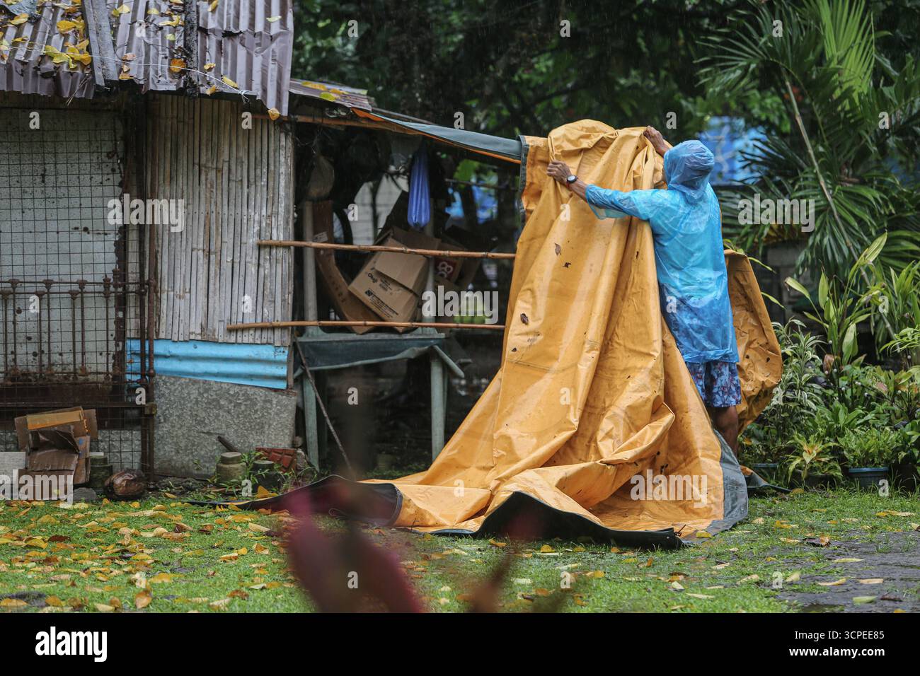 Calabarzon, Philippinen. September 2025. Ein philippinischer Mann versucht, sein Dach mit einer Plane zu schützen, nachdem die ersten schweren Regenfälle der Nacht in sein Haus einsickerten. Taifun Opong (Bualoi) wurde nach Landfall zu einem schweren tropischen Sturm herabgestuft, bringt aber immer noch mäßigen bis sintflutartigen Regen. Es ist der 15. Tropische Wirbelsturm des Jahres, der den philippinischen Archipel trifft, der auch durch die Wetterbedingungen durch habagat (Südwestmonsun) beeinflusst wird. Mindestens 120.000 Familien wurden evakuiert, insbesondere in den Provinzen Bicol und Quezon. Quelle: Kevin Izorce/Alamy Live News Stockfoto