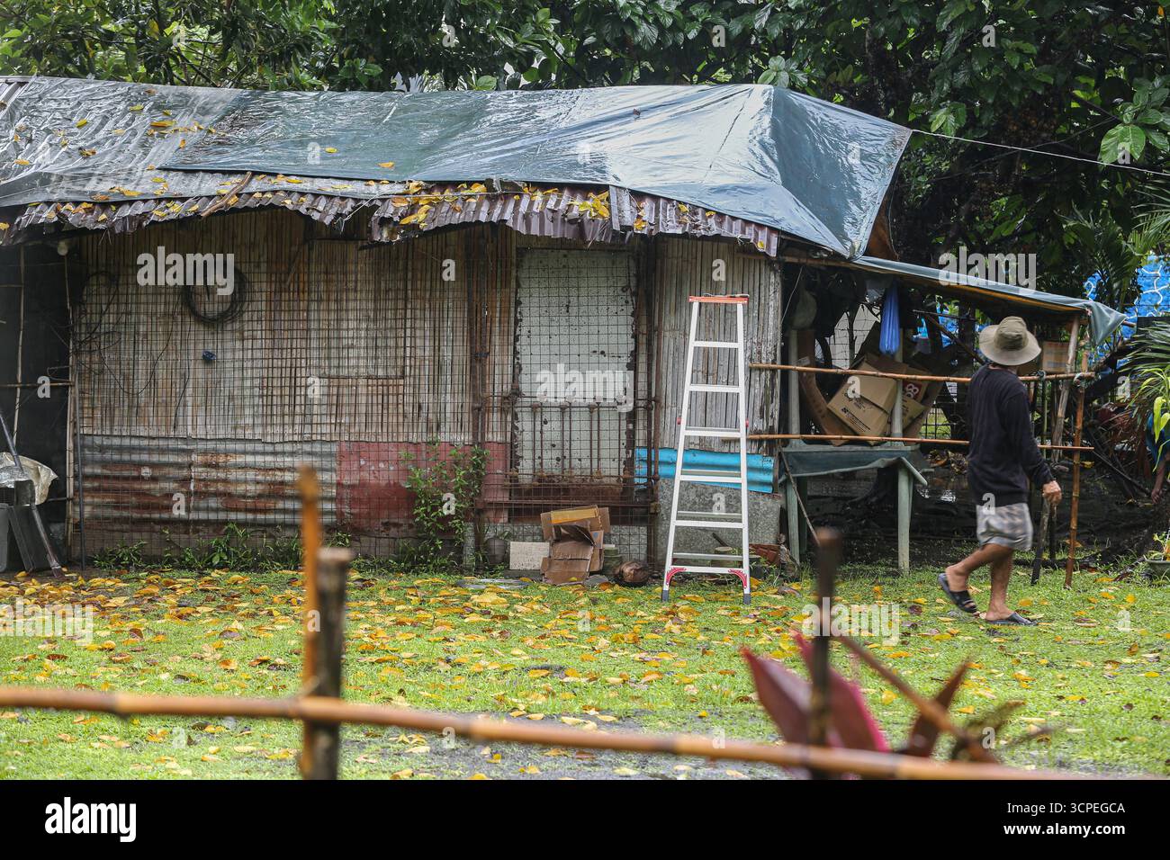 Calabarzon, Philippinen. September 2025. Ein philippinischer Mann versucht, sein Dach mit einer Plane zu schützen, nachdem die ersten schweren Regenfälle der Nacht in sein Haus einsickerten. Taifun Opong (Bualoi) wurde nach Landfall zu einem schweren tropischen Sturm herabgestuft, bringt aber immer noch mäßigen bis sintflutartigen Regen. Es ist der 15. Tropische Wirbelsturm des Jahres, der den philippinischen Archipel trifft, der auch durch die Wetterbedingungen durch habagat (Südwestmonsun) beeinflusst wird. Mindestens 120.000 Familien wurden evakuiert, insbesondere in den Provinzen Bicol und Quezon. Quelle: Kevin Izorce/Alamy Live News Stockfoto