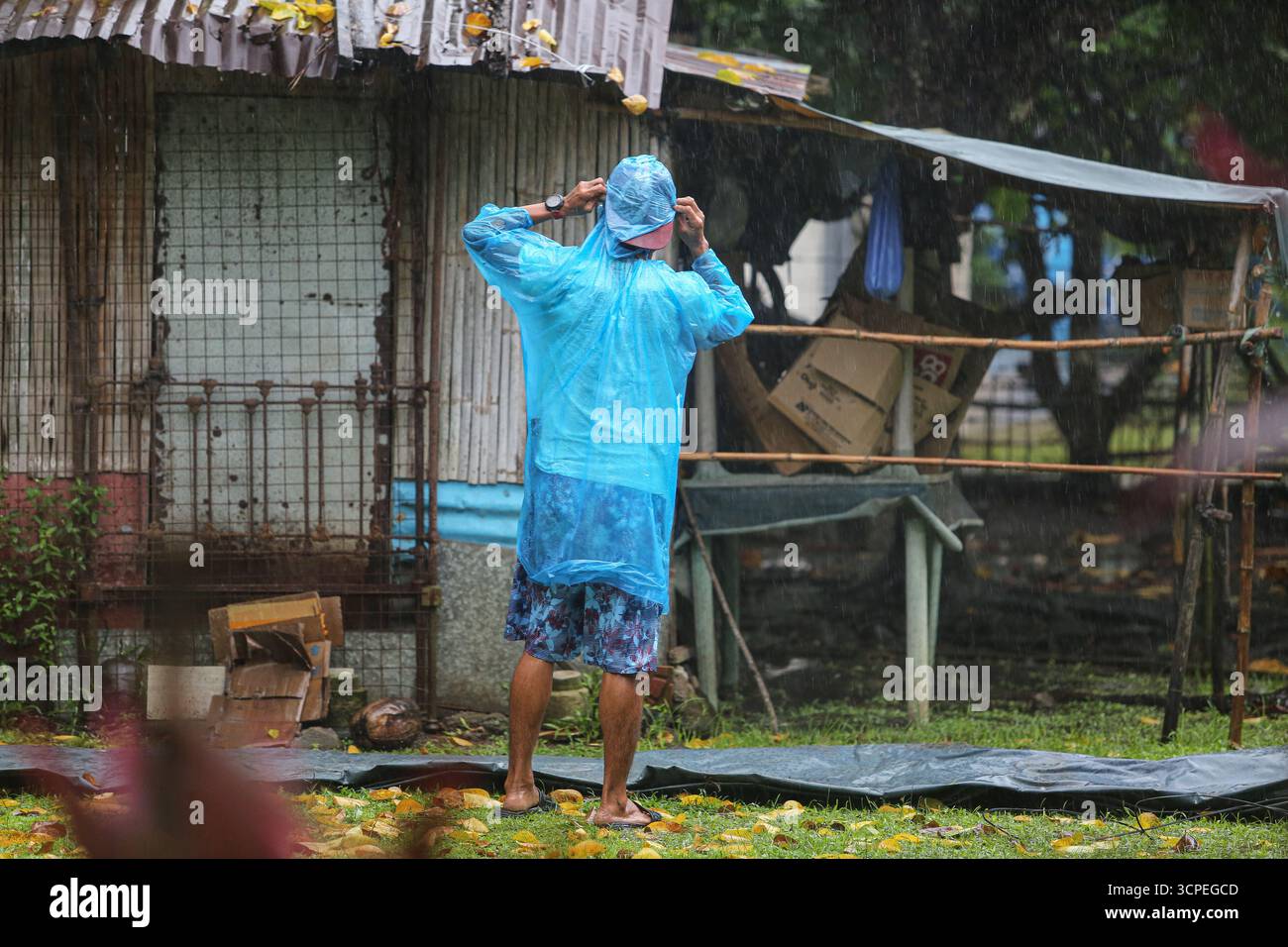 Calabarzon, Philippinen. September 2025. Ein philippinischer Mann versucht, sein Dach mit einer Plane zu schützen, nachdem die ersten schweren Regenfälle der Nacht in sein Haus einsickerten. Taifun Opong (Bualoi) wurde nach Landfall zu einem schweren tropischen Sturm herabgestuft, bringt aber immer noch mäßigen bis sintflutartigen Regen. Es ist der 15. Tropische Wirbelsturm des Jahres, der den philippinischen Archipel trifft, der auch durch die Wetterbedingungen durch habagat (Südwestmonsun) beeinflusst wird. Mindestens 120.000 Familien wurden evakuiert, insbesondere in den Provinzen Bicol und Quezon. Quelle: Kevin Izorce/Alamy Live News Stockfoto
