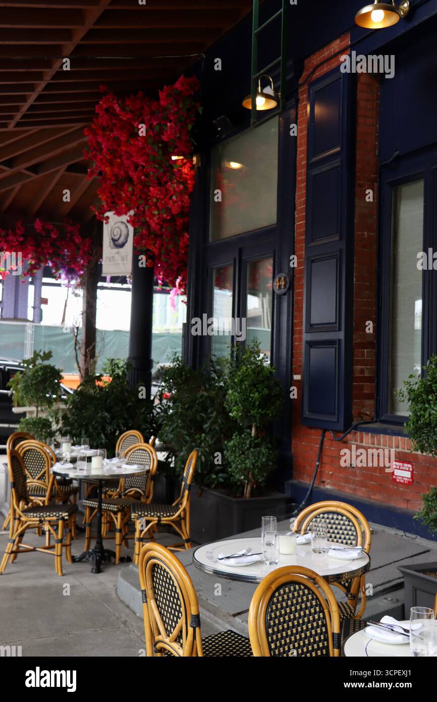 Tische draußen im historischen Paris Café an der Ecke Peck Slip und South Street am South Street Seaport in Downtown Manhattan, New York, September 2025 Stockfoto