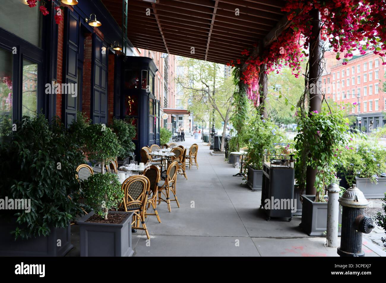 Tische draußen im historischen Paris Café an der Ecke Peck Slip und South Street am South Street Seaport in Downtown Manhattan, New York, September 2025 Stockfoto