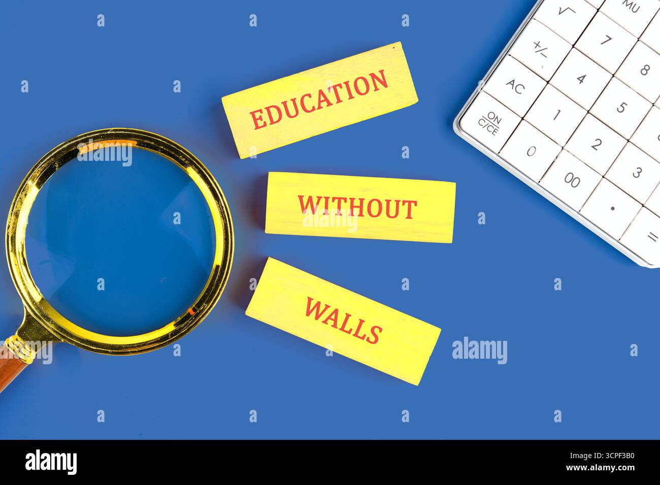 Kopierraum; Konzeptworte BILDUNG OHNE WÄNDE aus Holzblöcken auf blauem Hintergrund neben dem Rechner, Draufsicht. Stockfoto