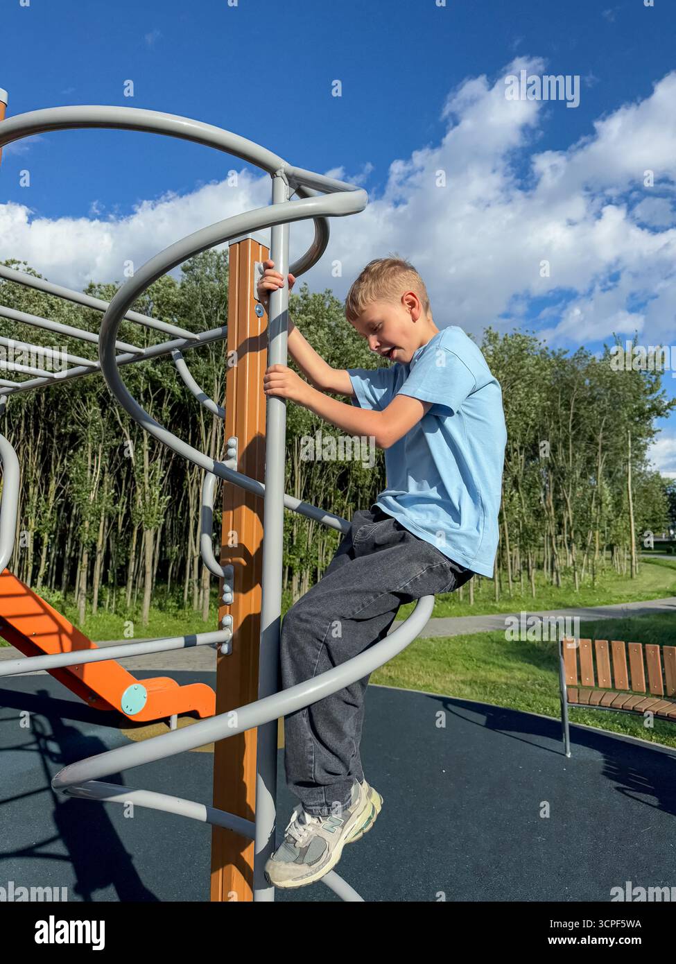Teen Boy, der an einem hellen Sommertag auf einem Sportspielplatz an den Pull-up-Bars trainieren kann, Fitness- und Aktivitätskonzept - Smartphone-aufgenommenes Stockfoto