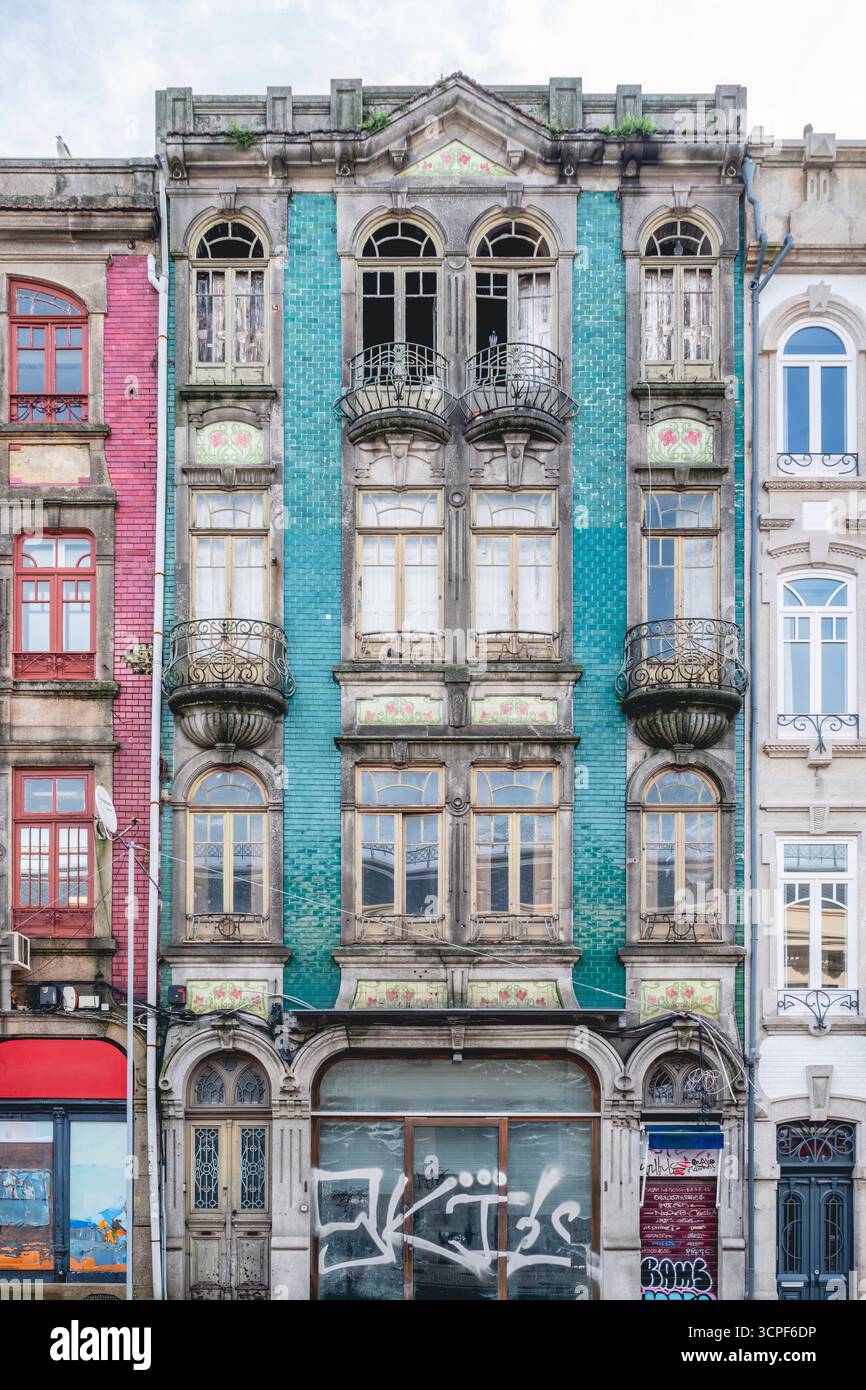 Historische Fassade des Oporto-Gebäudes mit verblassten Teal Azulejo-Fliesen und Balkonen aus verwittertem Eisen in Portugal. Architektonische Details, Urbaner Verfall Stockfoto