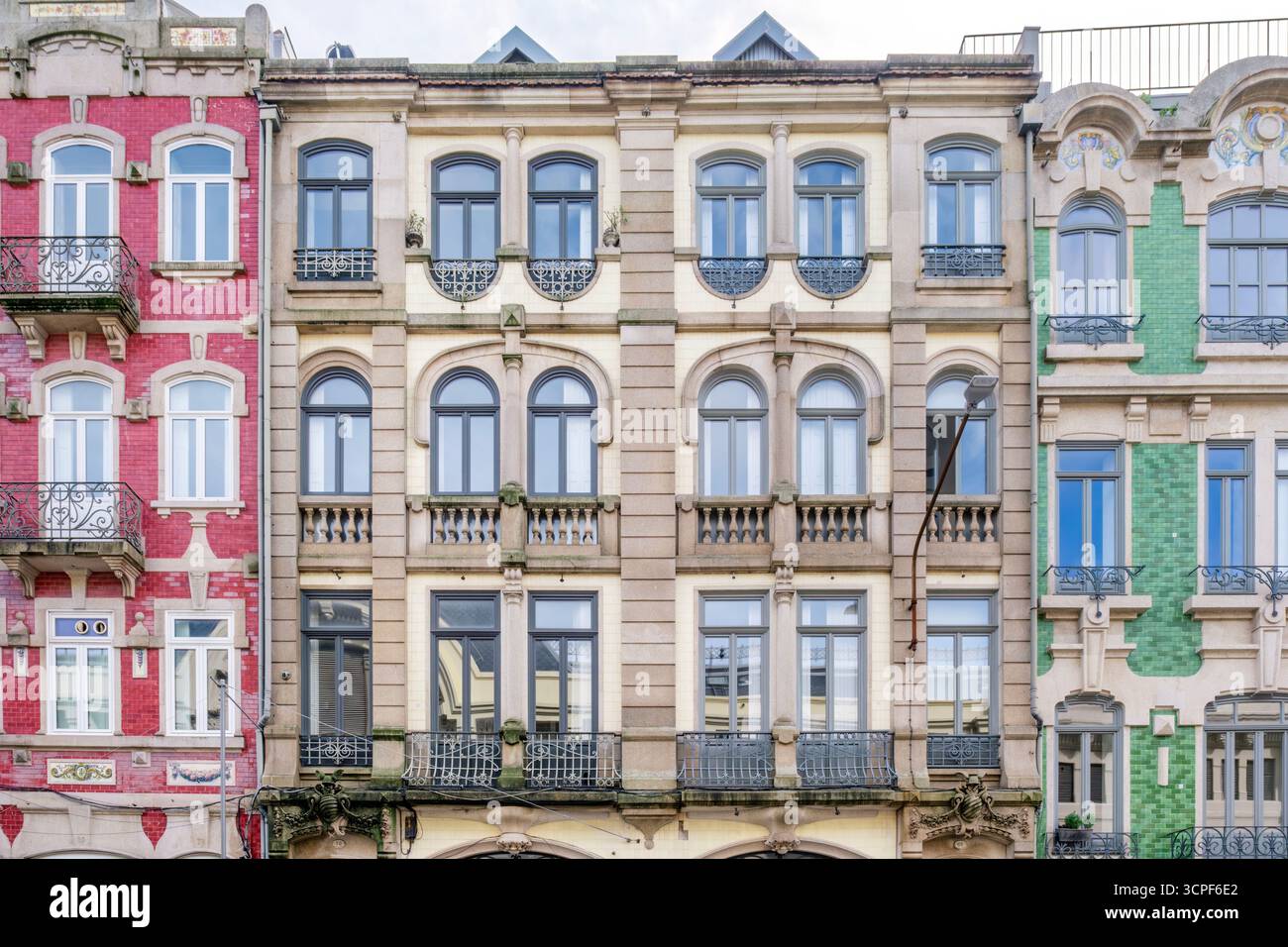 Eine Reihe von drei unterschiedlichen Fassaden des Porto-Gebäudes mit kontrastierenden Farben, historische Architektur in Portugal. Urbane Szene, Architektur, Azulejos Stockfoto