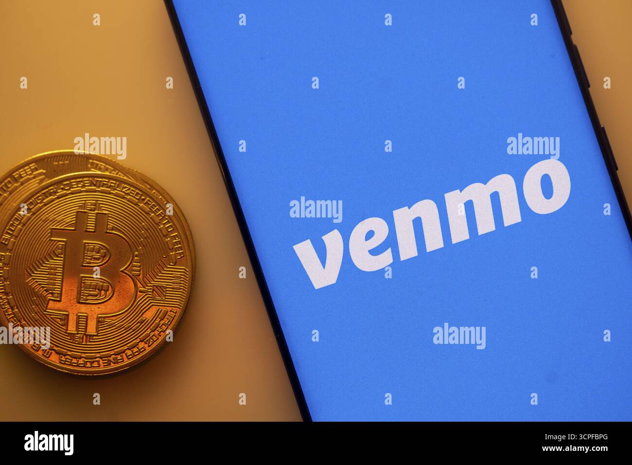 Ein Bitcoin- und Venmo-Logo auf einem blauen Bildschirm, das Kryptowährung darstellt Stockfoto