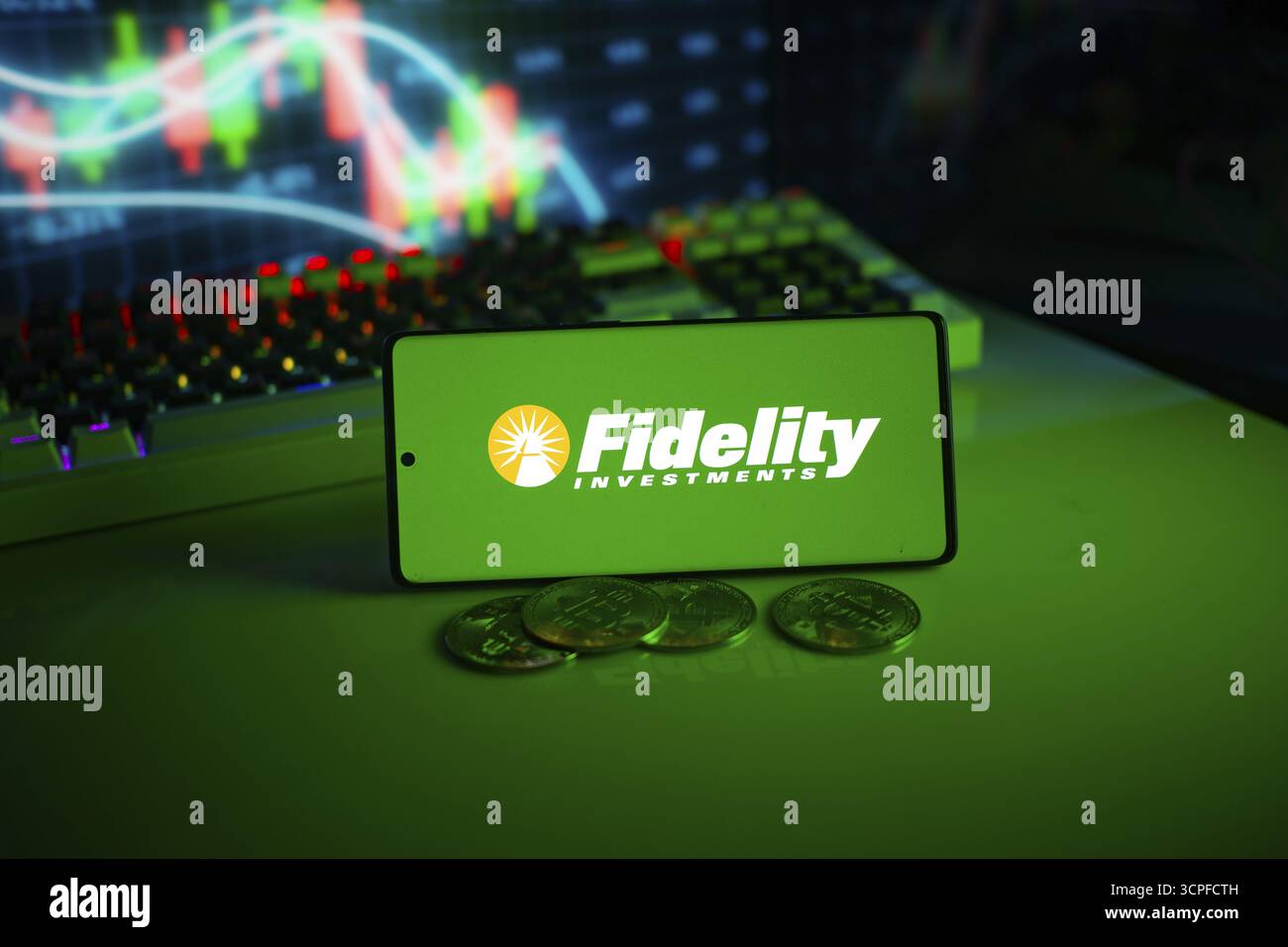 Logo für Treueanlagen auf grünem Bildschirm mit Münzen und Handelsdiagrammen im Hintergrund Stockfoto