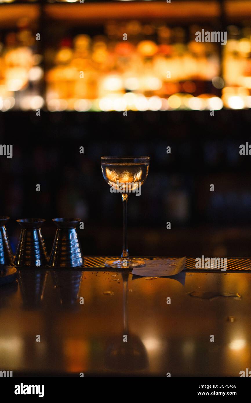 Elegantes Glas mit goldener Beleuchtung an der Bar Stockfoto