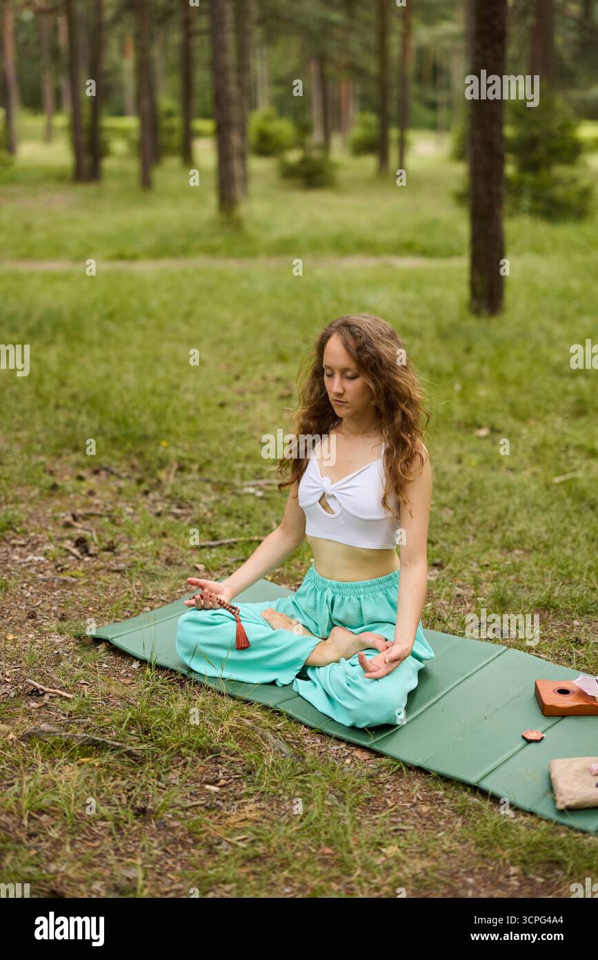 Meditation in der Natur umgeben von Bäumen an einem sonnigen Tag Stockfoto
