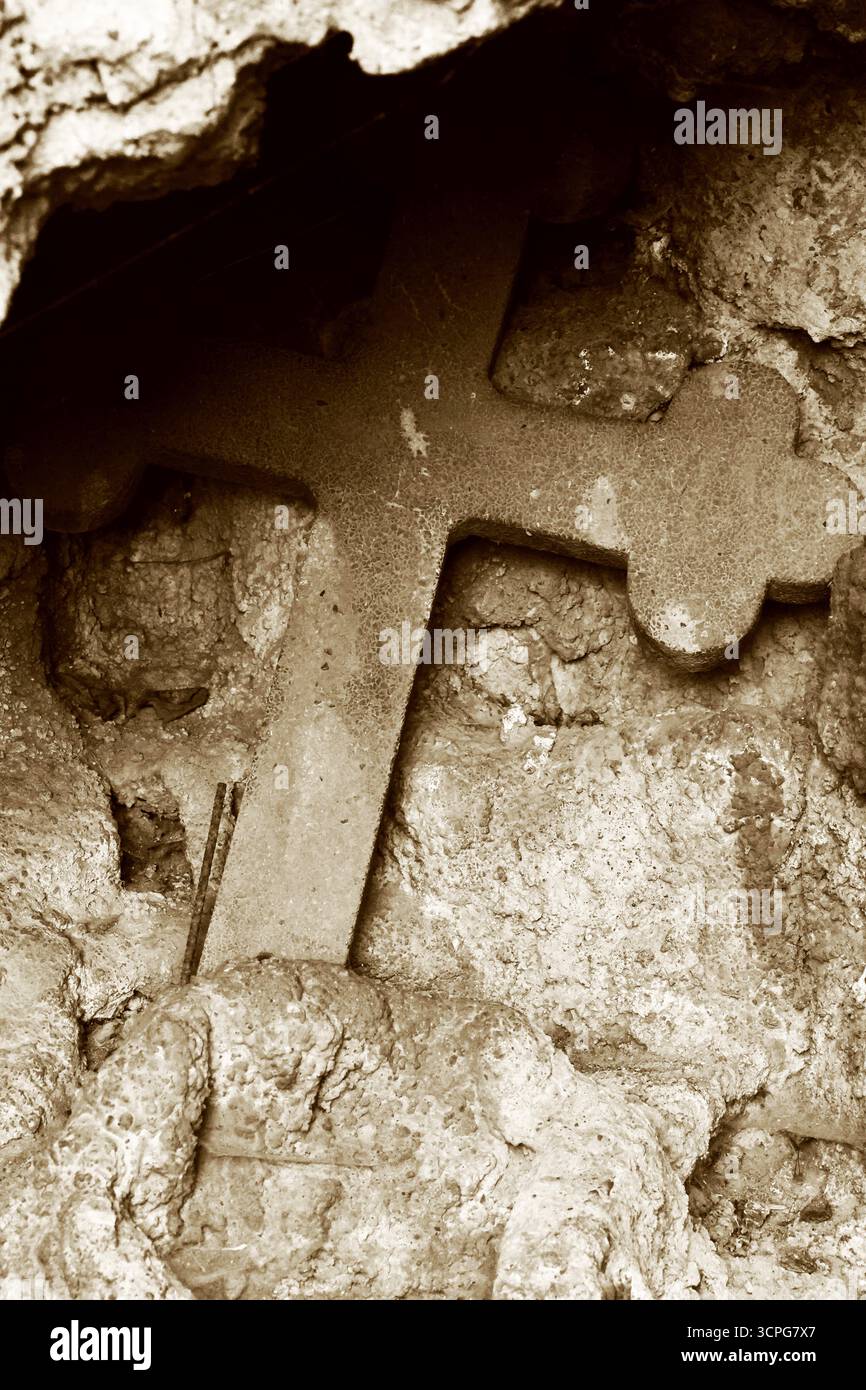 Altes heiliges Steinkreuz in einer rustikalen Nische Stockfoto