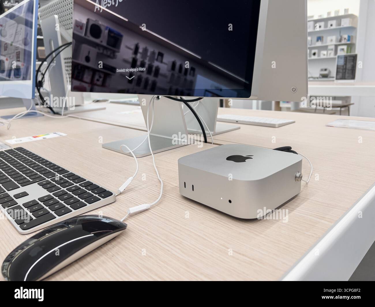 Posen, Polen – 20. September 2025: Ein Apple Mac Mini Computer, ein Magic Keyboard und eine Magic Mouse befinden sich auf einem sauberen Holzpult und zeigen neue Stockfoto