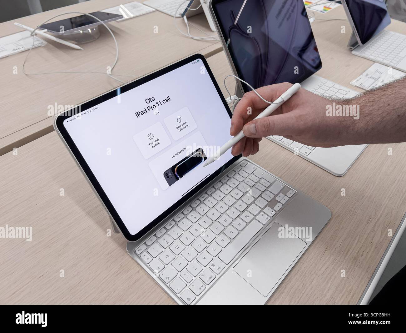 Poznan, Polen – 20. September 2025: Hand interagiert mit dem Bildschirm des Apple iPad Pro 11 über Apple Pencil, Magic Keyboard und zeigt eine leistungsstarke digitale Funktionalität Stockfoto