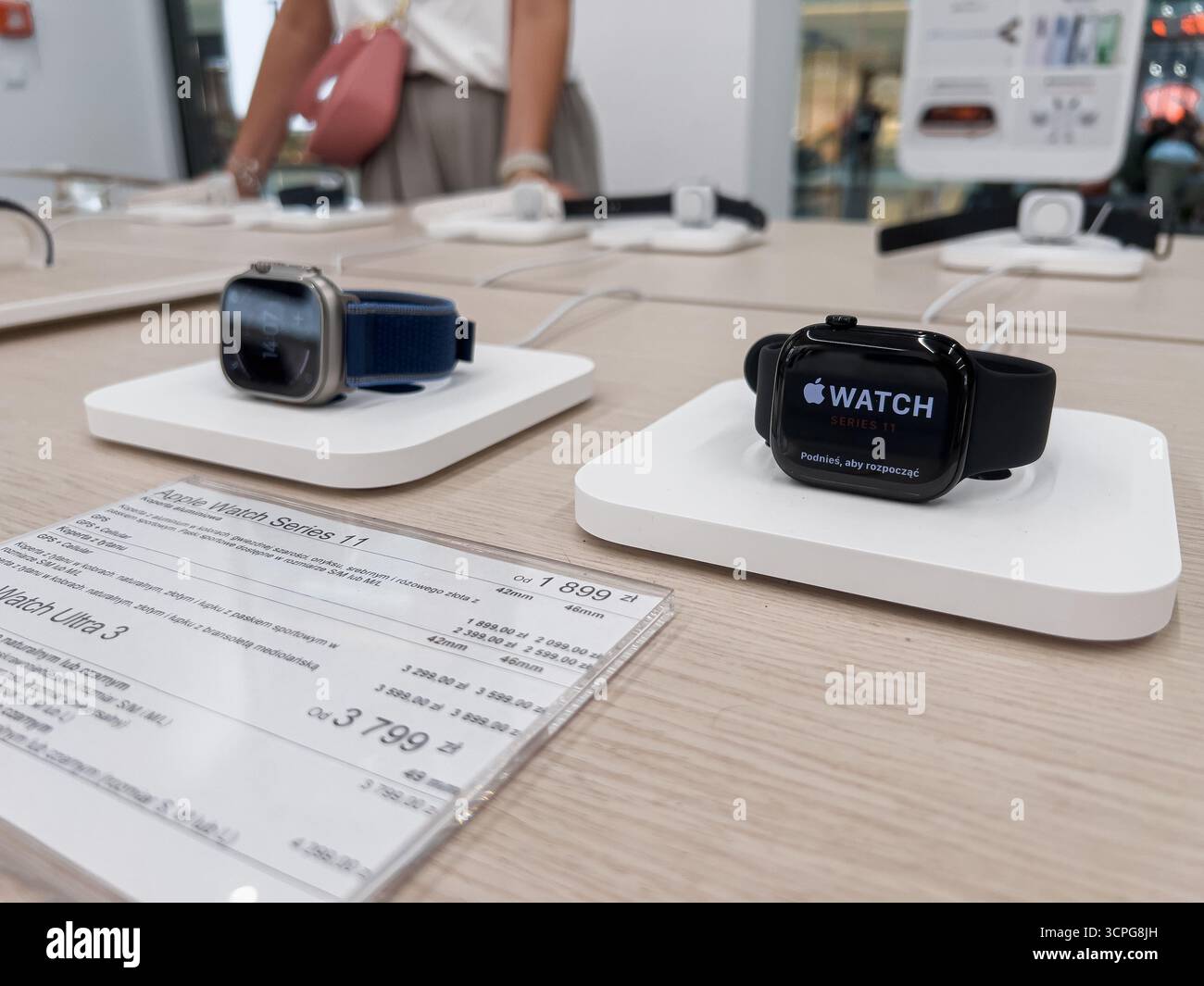Posen, Polen – 20. September 2025: Die Smartwatches Apple Watch 11 und Apple Watch Ultra 3 werden auf einzelnen weißen Ladestationen zum Verkauf angeboten Stockfoto