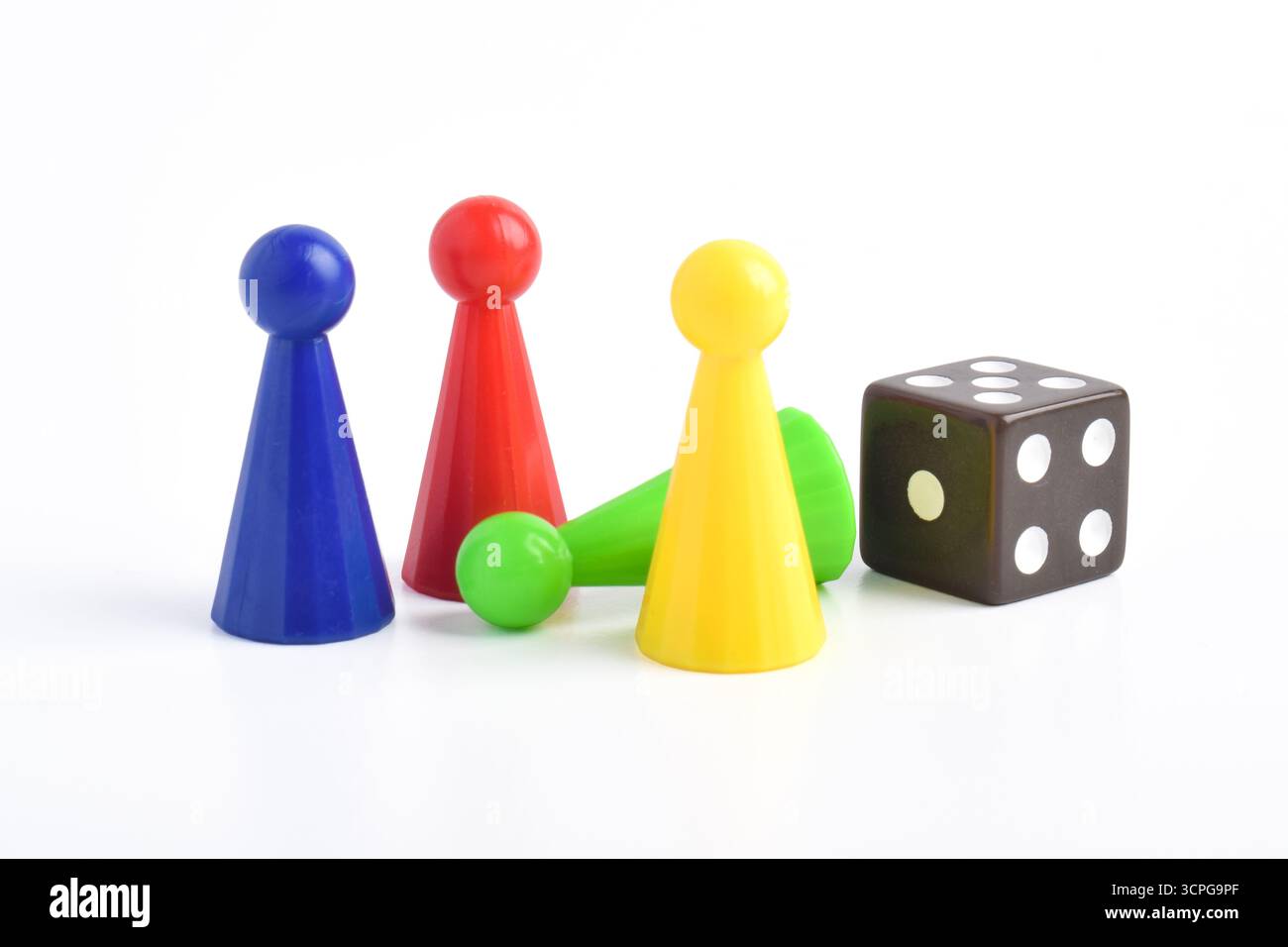 Bunte Brettspiel-Figuren und Würfel isoliert auf weißem Hintergrund Stockfoto