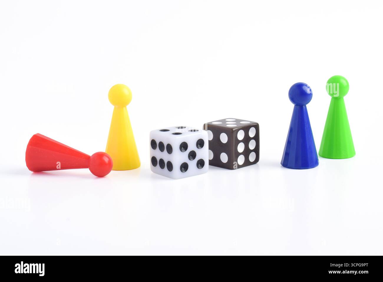Bunte Brettspiel-Figuren und Würfel isoliert auf weißem Hintergrund Stockfoto