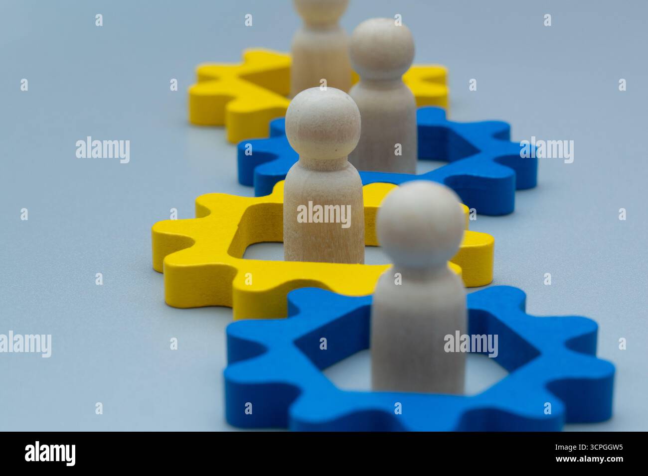 Holzfiguren in miteinander verbundenen Zahnrädern. Teamarbeit, Zusammenarbeit und die Vernetzung des Arbeitskonzepts. Stockfoto