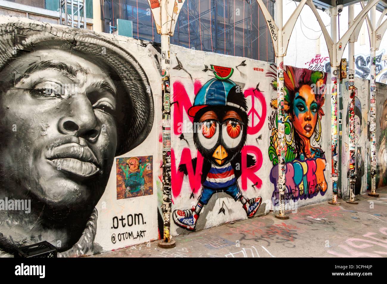 Städtisches Graffiti an der Wand mit farbenfroher Street Art, Porträt, Cartoon-Charakter und abstraktem Design von Otom in der Freemans Allee Bowery New York City NY Stockfoto