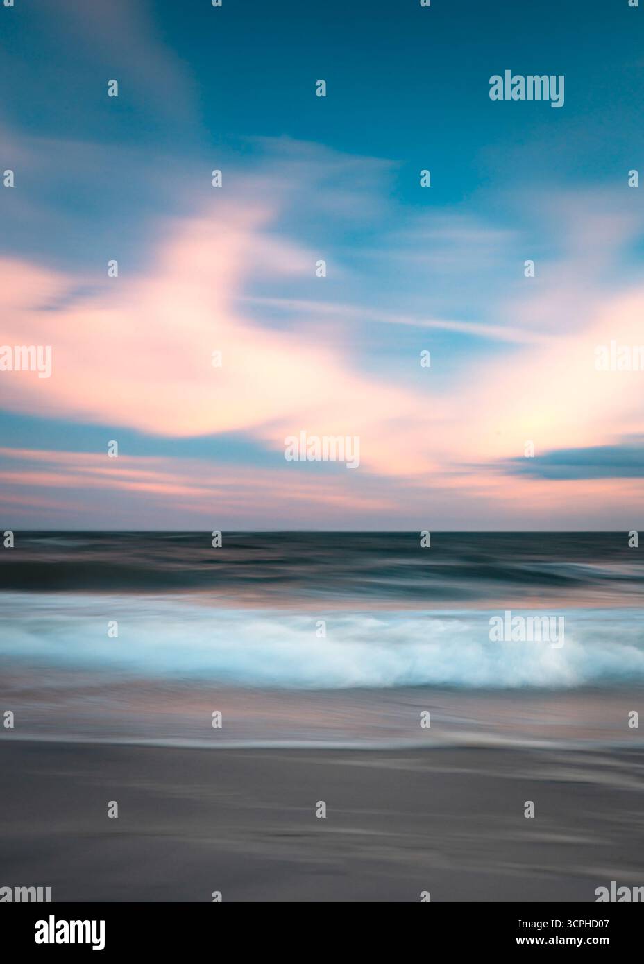 Lange Exposition abstrakte Meereslandschaft am Strand bei Sonnenuntergang mit fließender Meereswasserbewegung und farbenfrohem Himmel Stockfoto