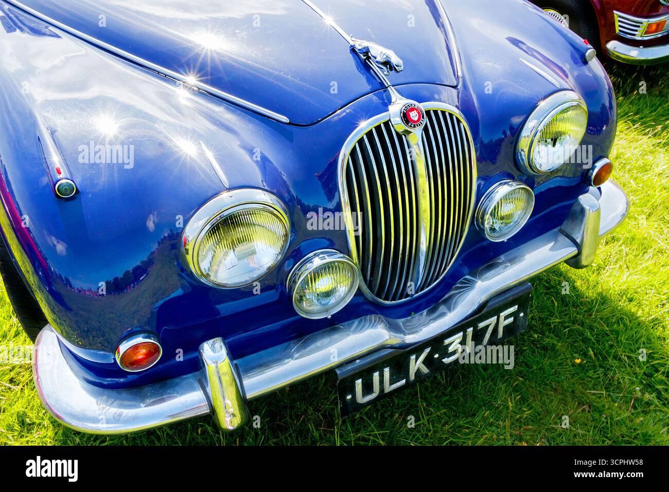 Nahaufnahme eines klassischen blauen Jaguar Mk 2 Oldtimers mit glänzendem Kühlergrill und Kennzeichen auf einer Oldtimerausstellung Stockfoto