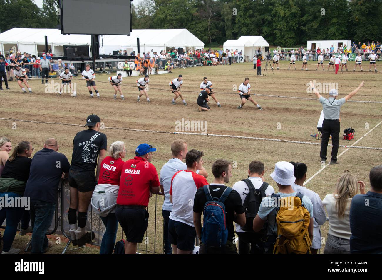 Das TUG of war-Team ist bereit für Action, mit Unterstützern im Vordergrund. Stockfoto